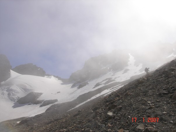 A climber traverses around towards Ball Pass in the mist.