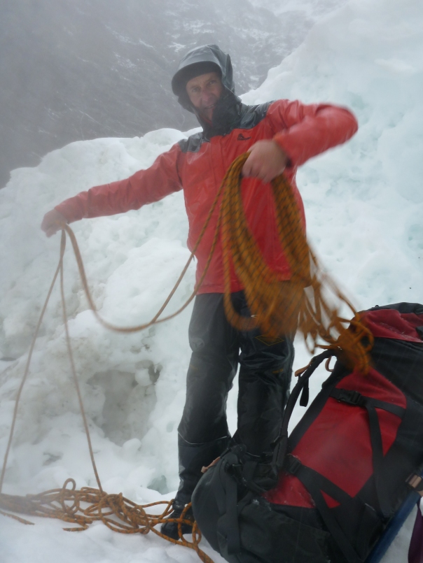 A cold and wet Alan Silva coils the rope as we prepare to leave in the morning.