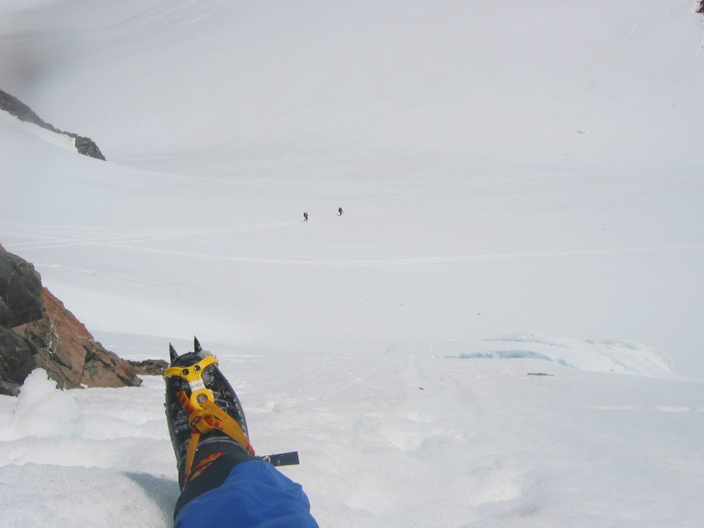 At the base of the rock buttress route on 9144. You need to cross a schrund to get here which is just visible a few  metres below my legs.
