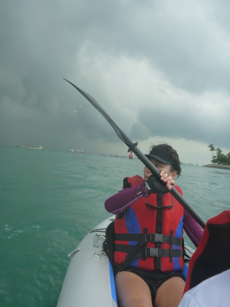 Leaving Tanjong Beach behind and making good time paddling with the current. Some big black clouds behind Stephanie's shoulder would eventually catch us out later.